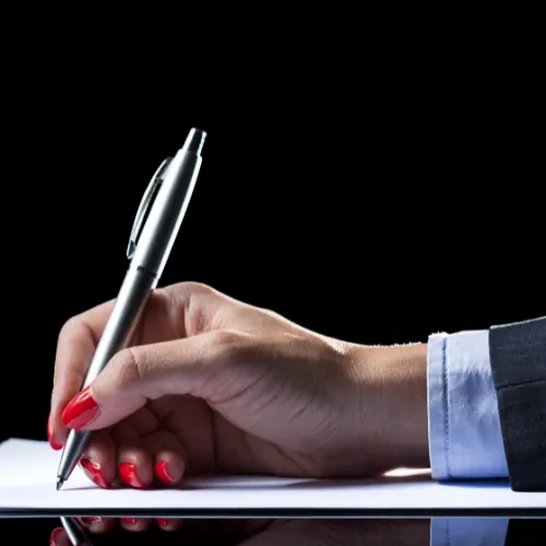 Hand notiert Beobachtungen mit einem Kugelschreiber auf Papier